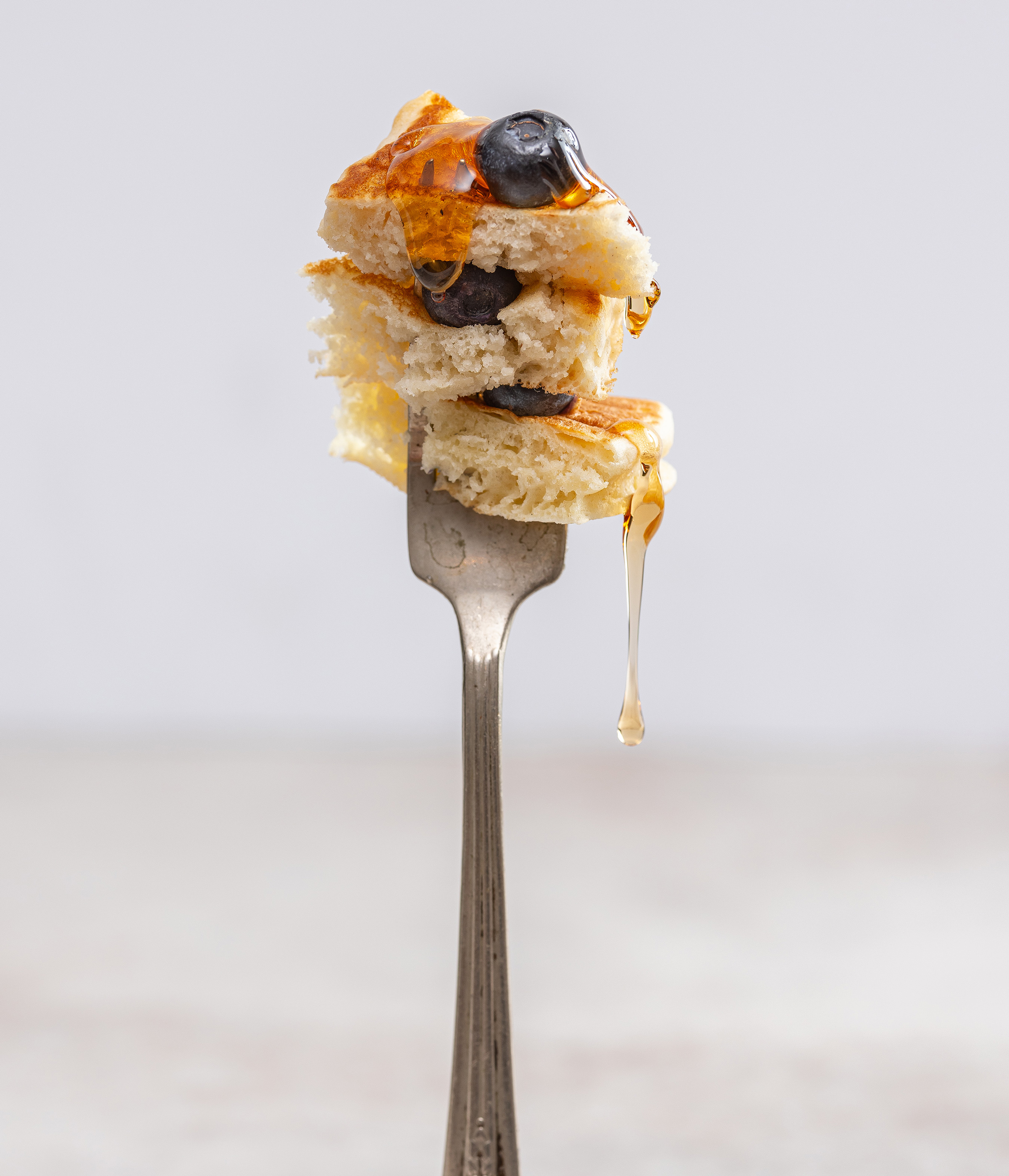 closeup of fork with pancake and blueberry syrup drip alyssa wernick food stylist styling dallas tx