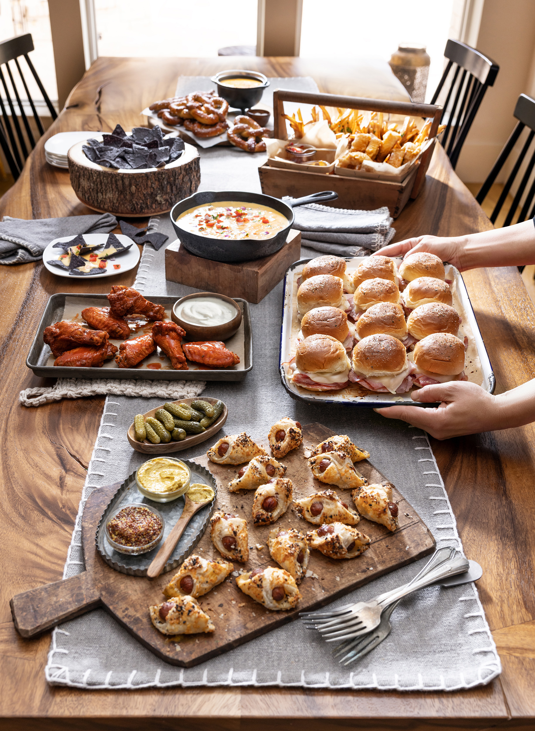 spread of pigs in blanket queso hot wings pretzels fries and onion rings alyssa wernick food stylist styling dallas tx