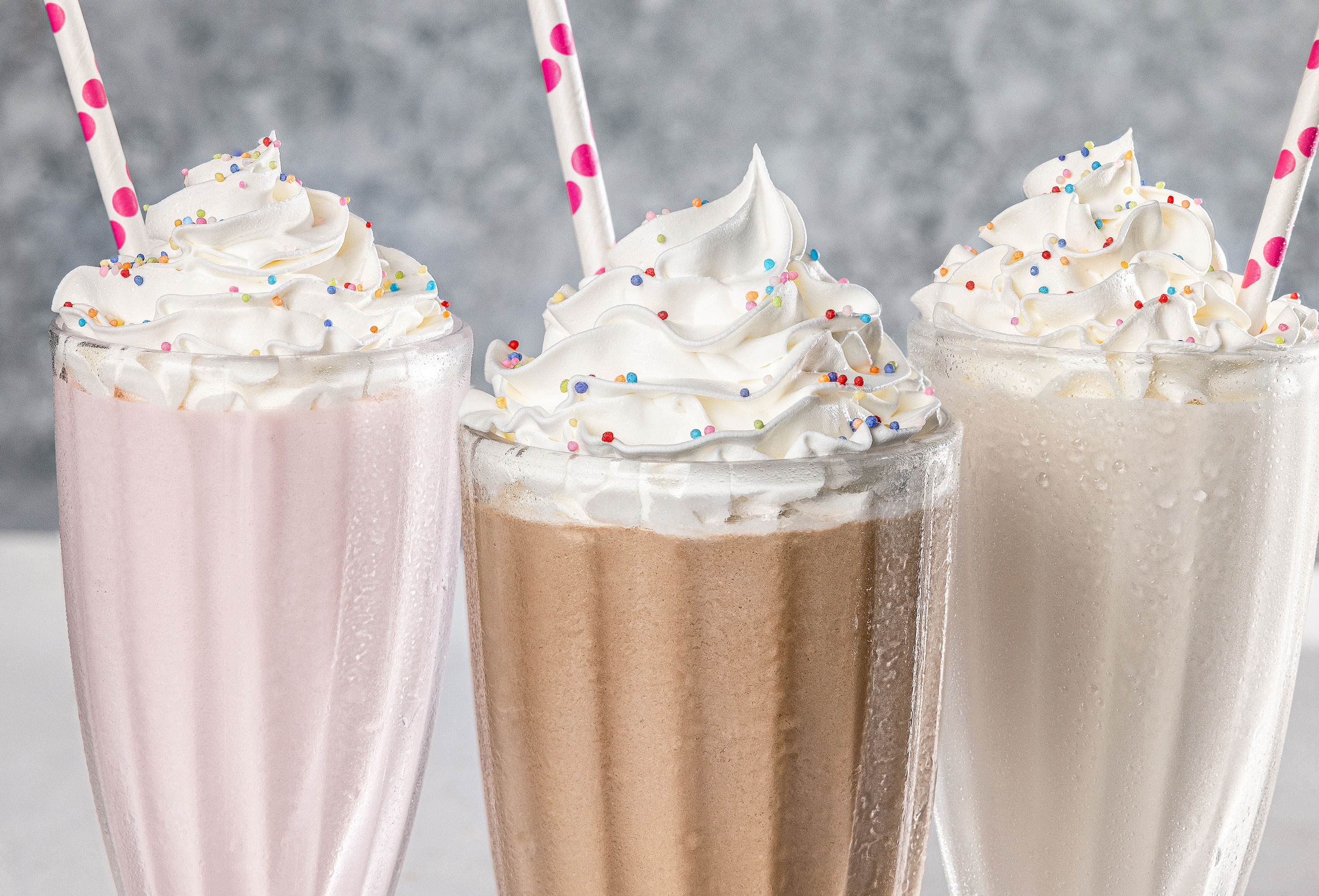 vanilla chocolate and strawberry milkshakes with whipped cream and sprinkles closeup alyssa wernick food stylist styling dallas tx